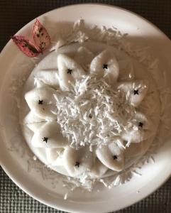 un plato blanco de comida con arroz y plátanos en Pousada Bahia Bella en Morro de São Paulo