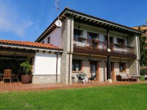 ein großes Backsteinhaus mit einem Balkon und einer Terrasse in der Unterkunft Villa Tiviti in Oviedo