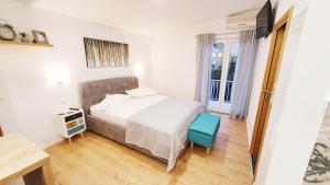a bedroom with a bed and a blue stool at Apartments Palma in Baška Voda