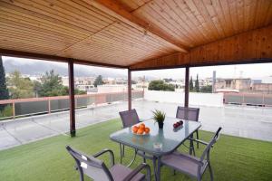 een patio met een tafel en stoelen op een dak bij Agia Paraskevi, a cozy and minimal retire in Athene