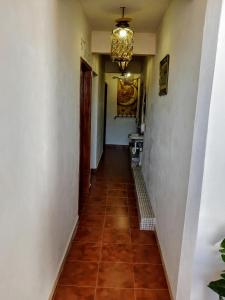 a hallway with a tile floor and a chandelier at Hotel Posada Spa Antigua Casa Hogar in Taxco de Alarcón