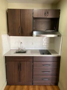 a kitchen with a sink and a microwave at Stratford House Inn and Suites Temple in Temple