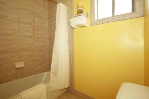 a bathroom with a tub and a toilet and a window at Regency Inn in Winnemucca