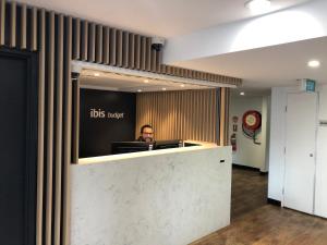a man sitting at a desk in an office at ibis Budget - Gosford in Gosford