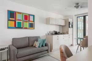 a living room with a couch and a kitchen at Q Square by Supercity Aparthotels in Brighton & Hove