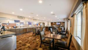 a restaurant with tables and chairs and a bar at Holiday Inn Express & Suites Chicago-Deerfield Lincolnshire by IHG in Riverwoods