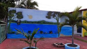 a mural on the side of a building with palm trees at Pousada Tropicaliente in Alter do Chao