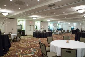 a banquet hall with white tables and chairs and tablesearcher at Holiday Inn Hotel & Suites Bloomington Airport by IHG in Bloomington