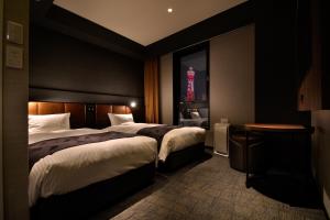 um quarto de hotel com duas camas e uma torre vermelha em Joytel Hotel Osaka Shinsekai em Osaka