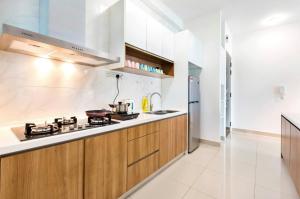 a kitchen with wooden cabinets and a stove top oven at Pinnacle Tower Homestay by Home Cube in Johor Bahru