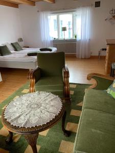 a living room with a bed and a chair and a table at Rävåkra Bed & Breakfast in Hammenhög