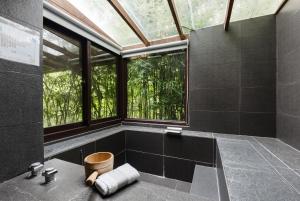ein Bad mit einer Dusche und einem großen Fenster in der Unterkunft Zhou Ye Cottage in Sanyi