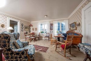 ein Wohnzimmer mit Stühlen und einem Tisch in der Unterkunft Nes Gard in Høyheimsvik