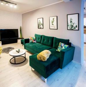 een woonkamer met een groene bank en een tafel bij Marlenka in Nysa