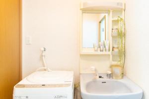 un bagno con lavandino, water e specchio di 一棟貸切宿, HARMONIA東京小岩 6名max,wifi有,秋葉原16分新宿33分,ディズニー電車48分, 駐車場ありません a Tokyo Altre 35 foto