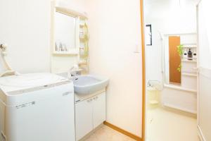 un bagno bianco con lavandino e specchio di 一棟貸切宿, HARMONIA東京小岩 6名max,wifi有,秋葉原16分新宿33分,ディズニー電車48分, 駐車場ありません a Tokyo