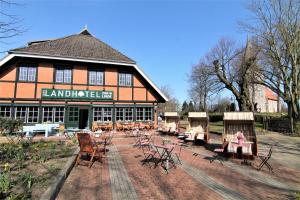 a building with chairs and tables in front of it at Landhotel garni zur Linde in Ratekau