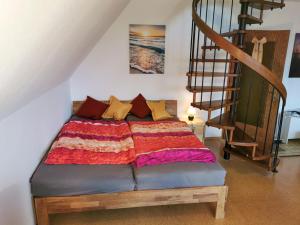 a bed in a room next to a staircase at Haus-Deichläufer in Westerdeichstrich