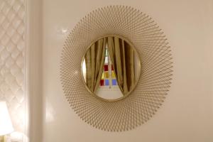 a circular mirror on a wall with a curtain at Riad Andallaspa in Marrakech