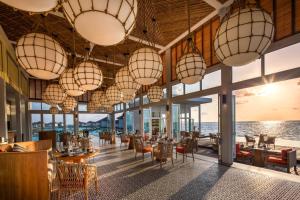 加弗阿利夫环礁Raffles Maldives Meradhoo的有桌椅和吊灯的餐厅
