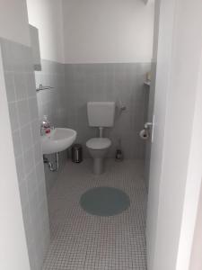 La salle de bains est pourvue de toilettes et d'un lavabo. dans l'établissement Ferienwohnung Post, à Ommersheim