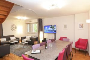 - un salon avec une table, des chaises et un canapé dans l'établissement ColmarAppart Vauban, à Colmar