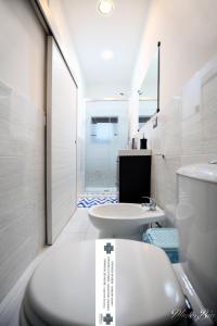 a white bathroom with a toilet and a sink at Home&Sharm Reitani in Catania
