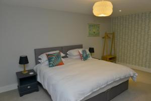 um quarto com uma grande cama branca com almofadas em 10A Ruston Chambers Free parking, Luxury 2 bedroom city center apartment em St Ives