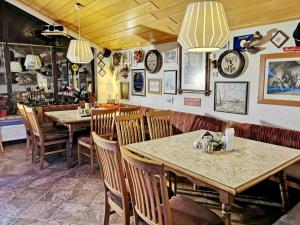 un restaurante con mesas, sillas y relojes en las paredes en Gästehaus Schachnerhöhe, en Steyr