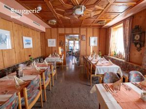 um restaurante com paredes e mesas e cadeiras de madeira em Hotel Restaurant Rätia em Filisur