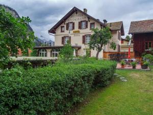 ein großes Haus mit einer Hecke davor in der Unterkunft Hotel Restaurant Rätia in Filisur