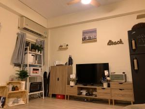 ein Wohnzimmer mit einem Flachbild-TV und einem Entertainment-Center in der Unterkunft That day Hostel 那天旅宿 in Lanyu