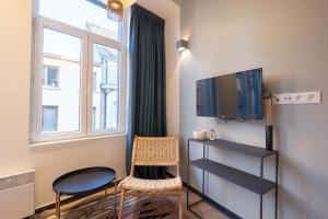 - un salon avec une télévision et deux chaises dans l'établissement The Light Blue Parrot, à Anvers