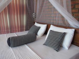 a bed with three pillows on top of it at The Rezt in Ella