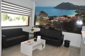 a living room with two couches and a large window at Hostal Solymar in Louro