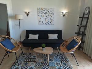 a living room with a blue couch and two chairs at Gerret in Can Picafort