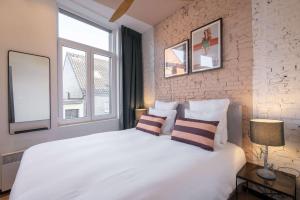 a bedroom with a large white bed with two pillows at SHWAY - The Pink Pigeon in Antwerp
