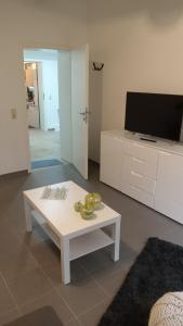 sala de estar con mesa de centro blanca y TV en Haus Harzland en Wernigerode