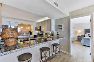 a kitchen with a counter and two bar stools at Horizons in Daytona Beach