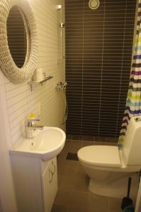 ein Badezimmer mit einem Waschbecken, einem WC und einem Spiegel in der Unterkunft Strandheimen Guesthouse in Melhus