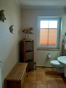 a bathroom with a sink and a toilet and a window at Waldidyll in Ostseebad Karlshagen