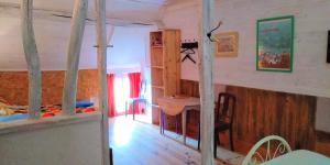 a room with a bed and a desk in a room at Ferme de l'Art Rural et Populaire in Maillot