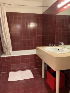 baño de azulejos rojos con lavabo y bañera en Appart Hyper Centre - Le Chapelet en Burdeos