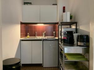una pequeña cocina con armarios blancos y fregadero en Appart Hyper Centre - Le Chapelet en Burdeos
