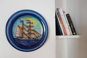 a blue plate with a picture of a ship on a wall at Agios Petros By the Sea in Aghios Petros Alonissos