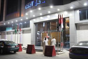 two men in white robes standing outside of a building at Al Thanaa Alraqi Furnished Apartments in Jeddah