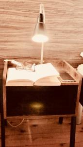 a table with a lamp and a book and glasses at Apartments Altstadthaus Görlitz in Görlitz