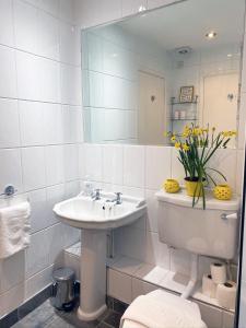 a white bathroom with a sink and a mirror at The Baltic SA by Serviced Living Liverpool in Liverpool