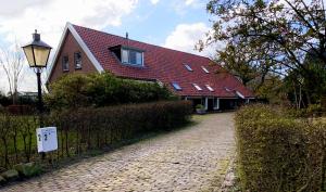 a house with a red roof on a brick road at Appartement Soerte Es in Wapse