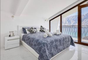 ein Schlafzimmer mit einem Bett und einem großen Fenster in der Unterkunft Apartments Bonaca in Kotor